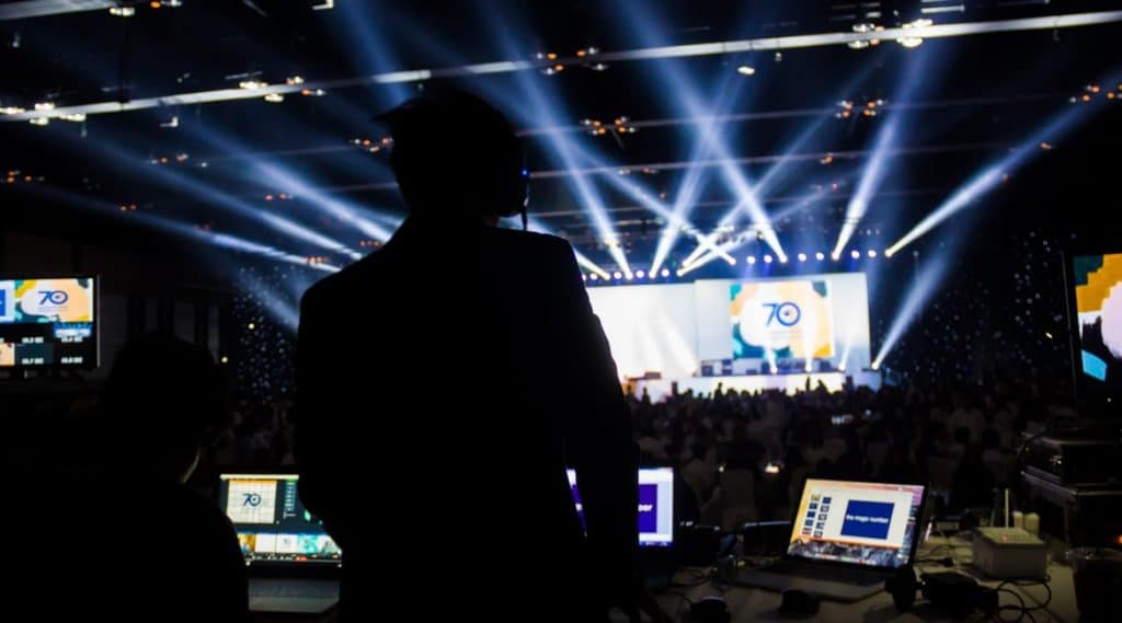 Ein Techniker steuert mit einem Showcontroller die Videotechnik und Lichttechnik bei einer großen Produktpräsentation in einer Halle.
